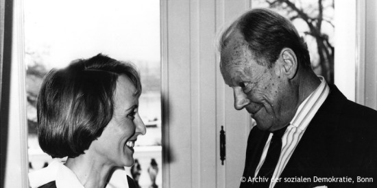 Willy Brandt und Brigitte Seebacher-Brandt. Sie blicken sich lächelnd an. Fotografie in Schwarz-Weiß. Öffnet weitere Informationen zu dieser Ehe.