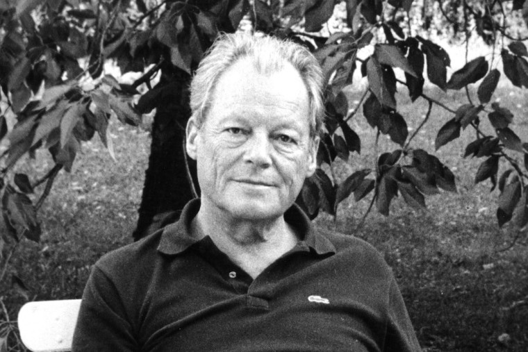 Schwarz-Weiß-Porträt von Willy Brandt aus dem Jahr 1985. Im Hintergrund ist ein Baum zu sehen.