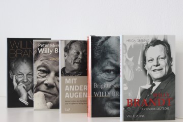 Aufreihung von Buchcovern: „Willy Brandt. Life of a Statesman“, „Willy Brandt 1913 – 1992. Visionär und Realist“, „Mit anderen Augen. Versuch über den Politiker und Privatmann Willy Brandt.“, „Willy Brandt“ und „Willy Brandt. Der andere Deutsche“. Öffnet eine Liste mit Biografien, Monografien und Sammelbände über Willy Brandt.