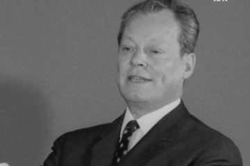 Leicht verpixeltes Schwarz-Weiß Porträt von Willy Brandt aus dem Jahre 1970. Am unteren rechten Rand sind leicht zwei Mikrophone zu erkennen. In der oberen rechten Ecke ist das Logo nrk zu sehen.