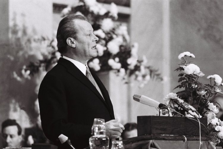 Schwarz-Weiß-Aufnahme von Willy Brandt vor einem Rednerpult im Jahre 1971.